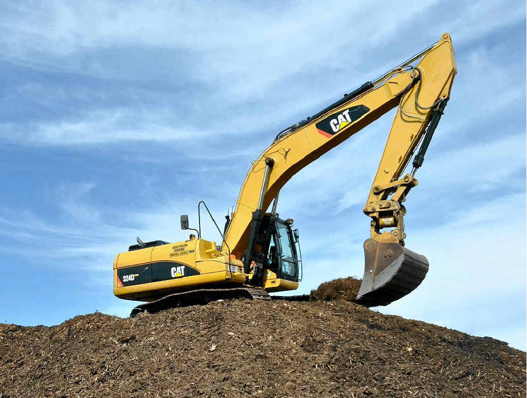 CLEANING UP: Council workers separate the burnt material at Allora dump.